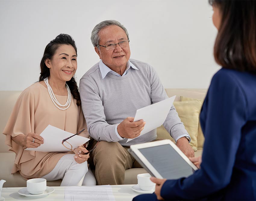 Couple sitting on couch in living room talking to interior designer