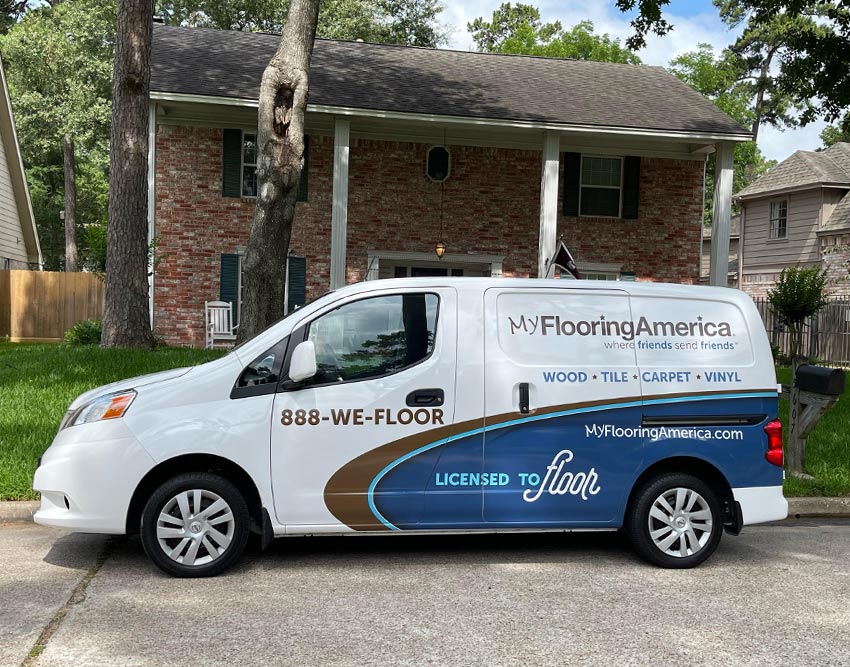 My. Flooring America van parked in front of brick house on sunny day
